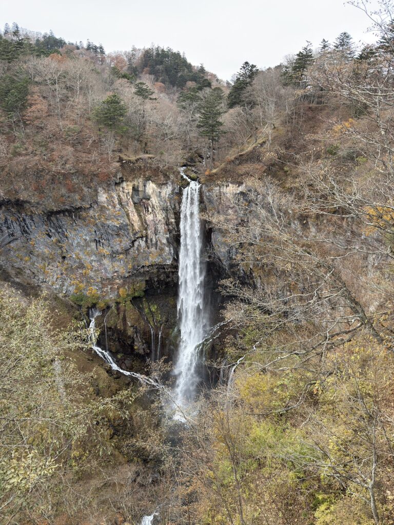 秋の奥日光にある華厳の滝を正面から撮影した風景。迫力ある落差と紅葉に囲まれた美しい景観。