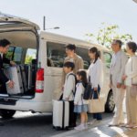 国土交通大臣許可のジャンボタクシー運転手が笑顔で乗客を出迎える様子