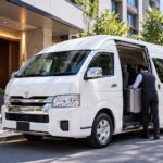 MIMARU東京前で乗客を待つ白の貸切ジャンボタクシー(トヨタ・ハイエース)