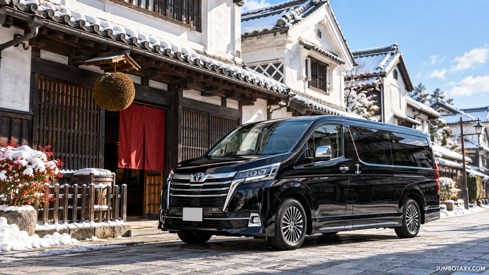 A black Toyota GranAce luxury taxi parked in front of a sake brewery with white walls and cedar trees
