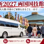 両国国技館の前に停まる白い大型ジャンボタクシーと、初場所を観戦しに向かうグループ